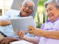 Casal idoso se entretendo em frente a um tablet: conheça nossas dicas e orientações posturais em osteoartrite