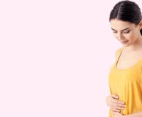 Mulher grávida olha para a barriga se formando: o primeiro trimestre de gestação traz muitas mudanças