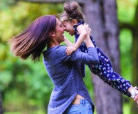 Mãe com filha no colo se divertindo em parque: qualidade de vida na SII