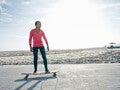 Mulher de meia idade anda de skate na praia em alusão a adotar um estilo de vida saudável no trabalho