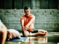 Homem praticando ioga em estúdio: impacto positivo do exercício na redução do colesterol