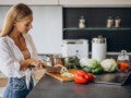 Mulher prepara refeição saudável em casa